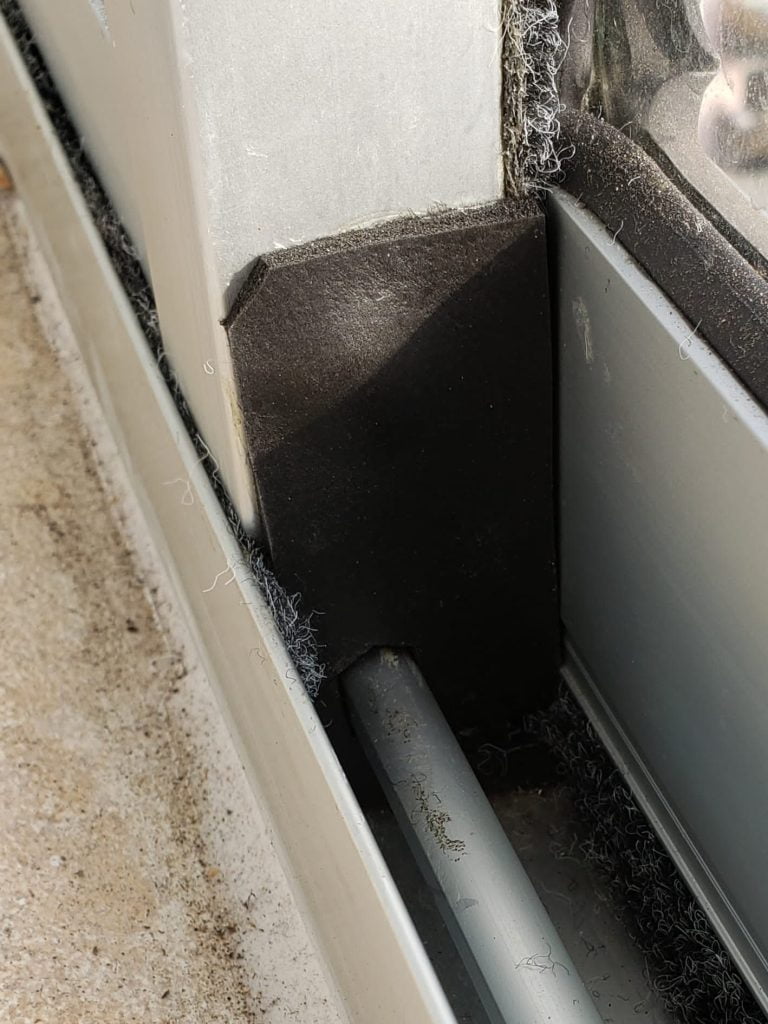 Ventana de aluminio color gris, totalmente cerrada y aislada en su parte exterior, interior y en sus juntas, con burletes de fieltro color gris y de goma color negro.